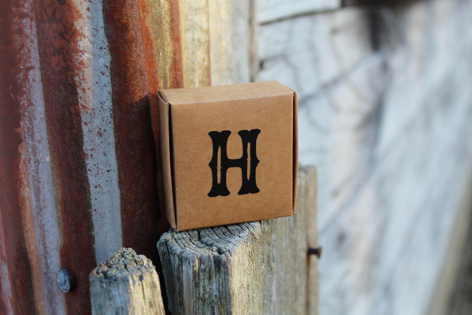 Big H branded box against weathered wood and rusted metal
